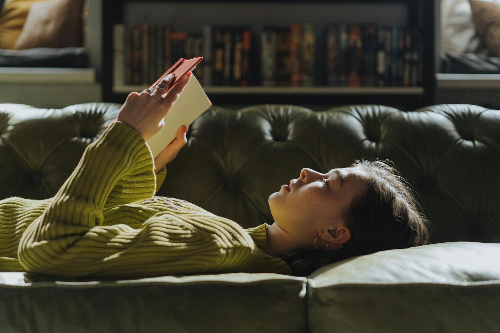 woman in yellow long sleeve shirt lying on couch